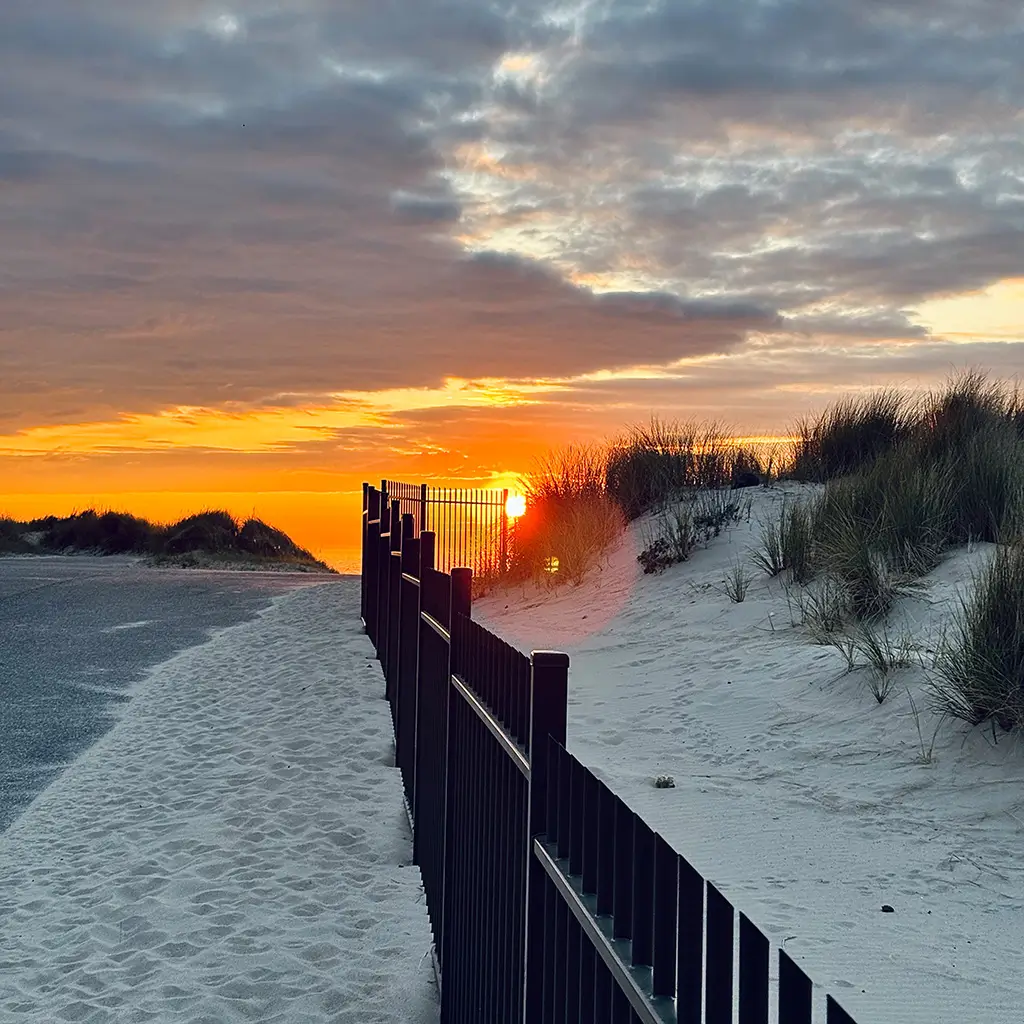 Sonnenuntergang in Breskens hinter den Dünen – goldene Stunde an der Nordsee mit dramatischem Himmel und Sandweg